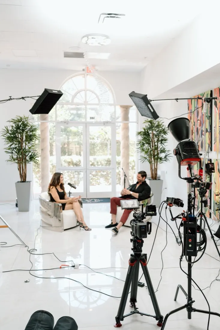 Mirit Moon hosting a podcast interview with a guest in the studio