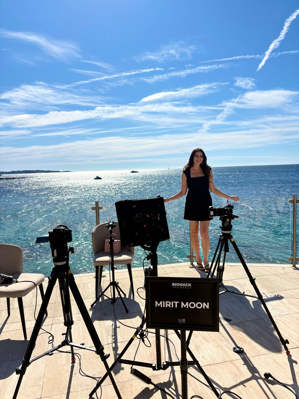 Mirit Moon on set by the sea, behind her name card